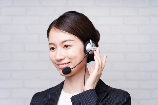 ヘッドセットを付けたスーツ姿の女性スタッフ