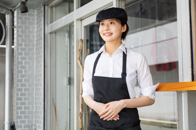 店先に立つエプロン姿の女性店員