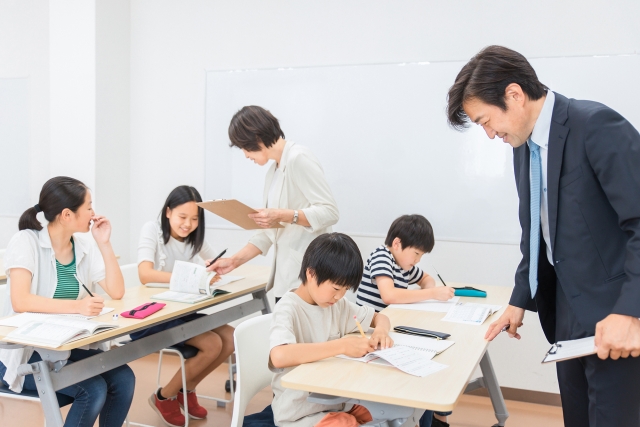 子どもたちに集団で授業を行う2名の講師