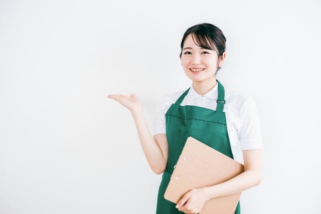 バインダーを片手にお客様をご案内する女性スタッフ