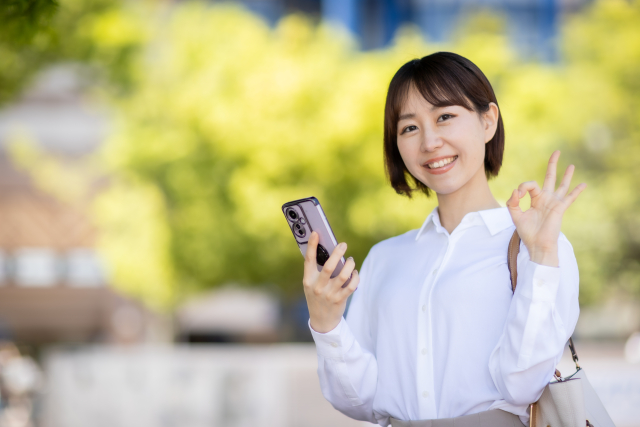 片手でOKマークを作る女性