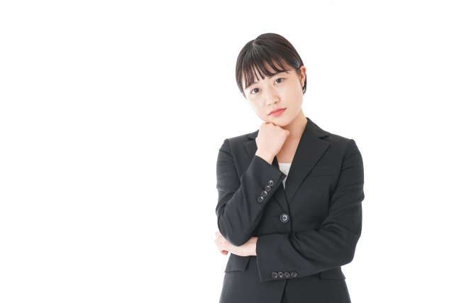 スーツ姿で考え込む女性
