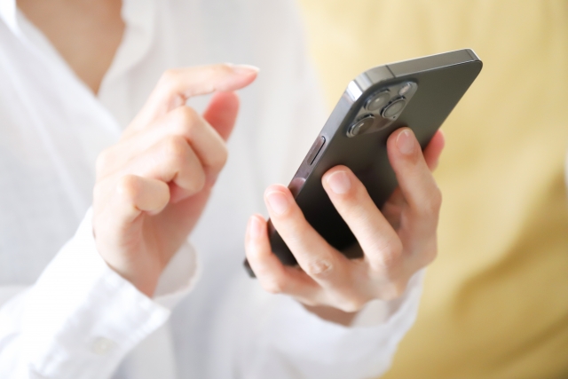 スマホを操作する女性の手元のイメージ