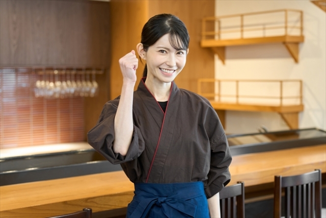 カウンター前でガッツポーズする女性店員