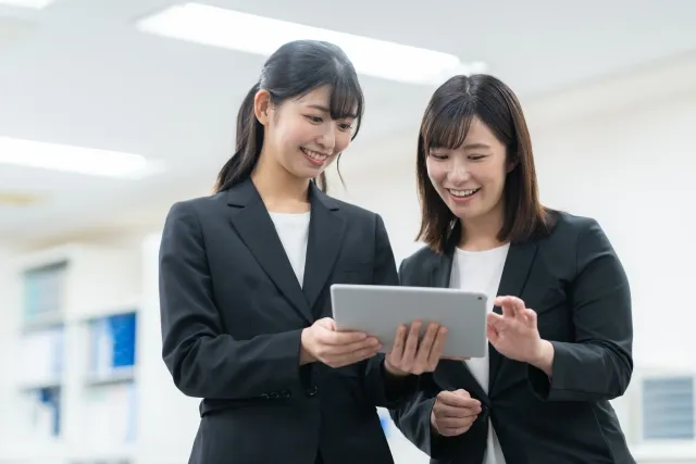 タブレットを見ながら話す女性たち