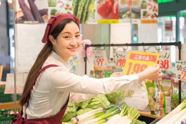 店内のPOPを張り替えるスーパーの女性店員