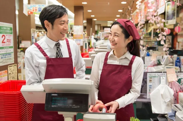 微笑み合うスーパーの店長と店員