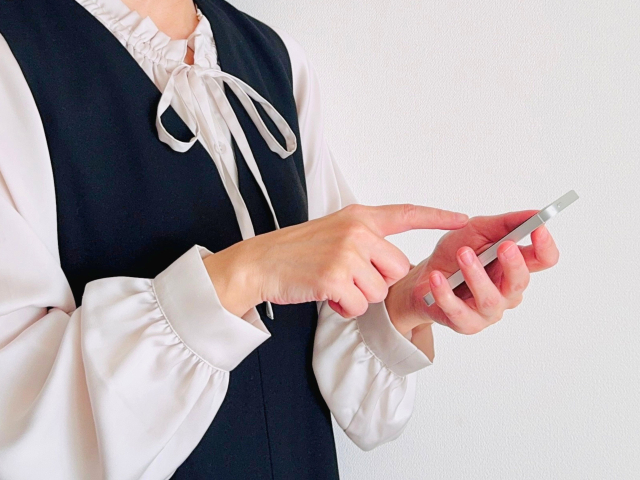 スマートフォンを持つ女性の手元